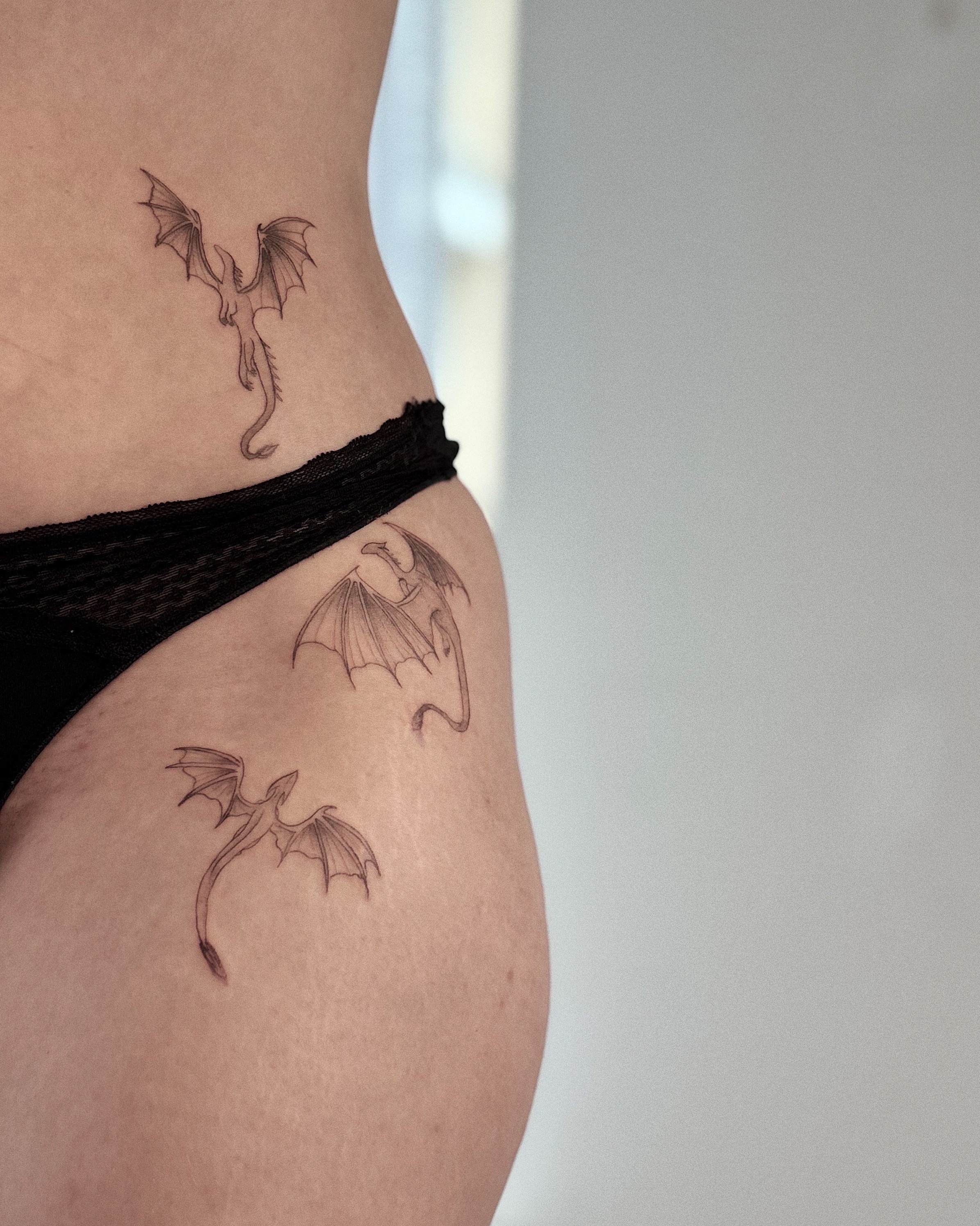 Musta-harmaa tatuointi, kolme lohikäärmettä